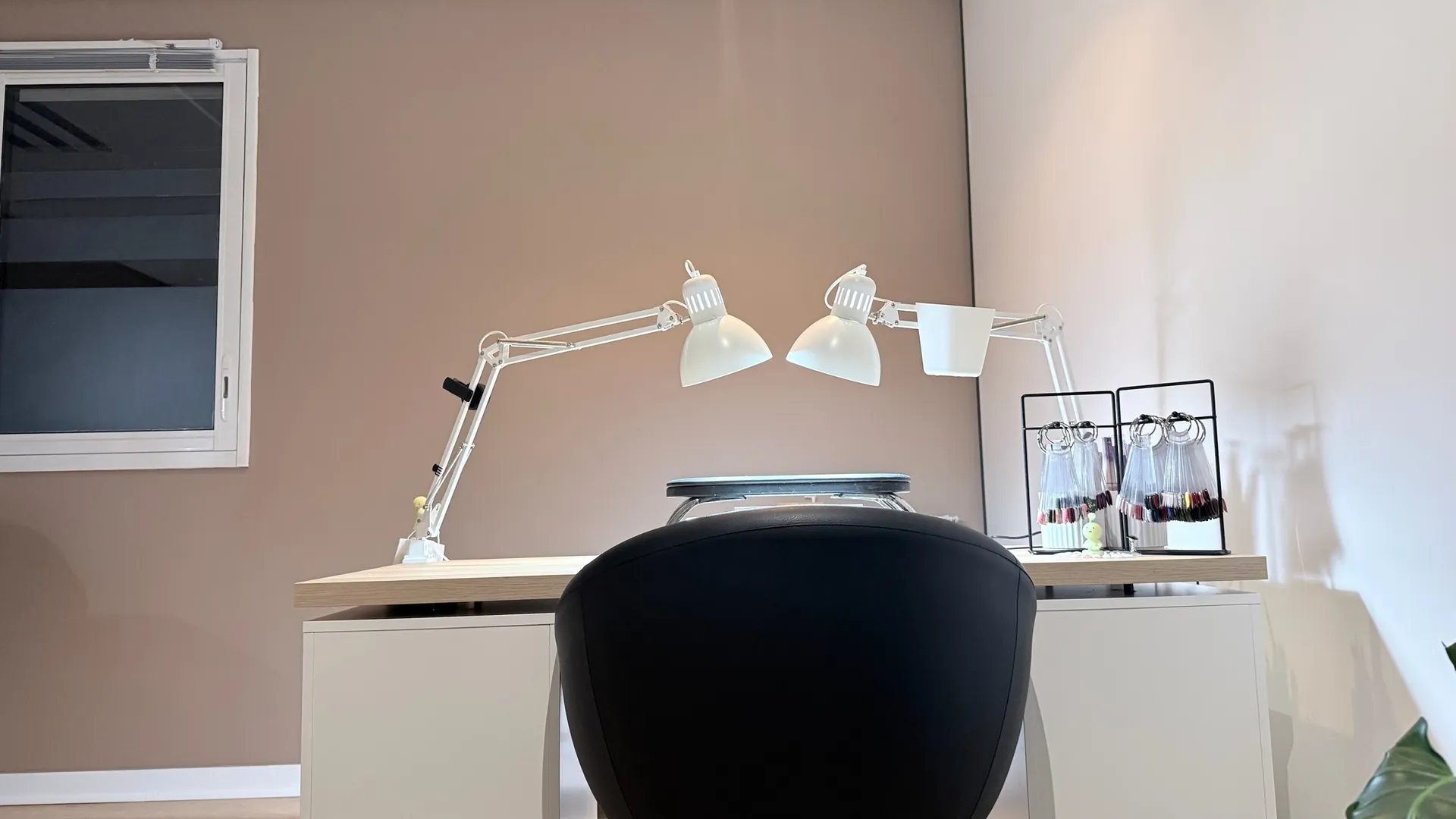 Poste de manucure — lampes, palette de vernis et mur rosé