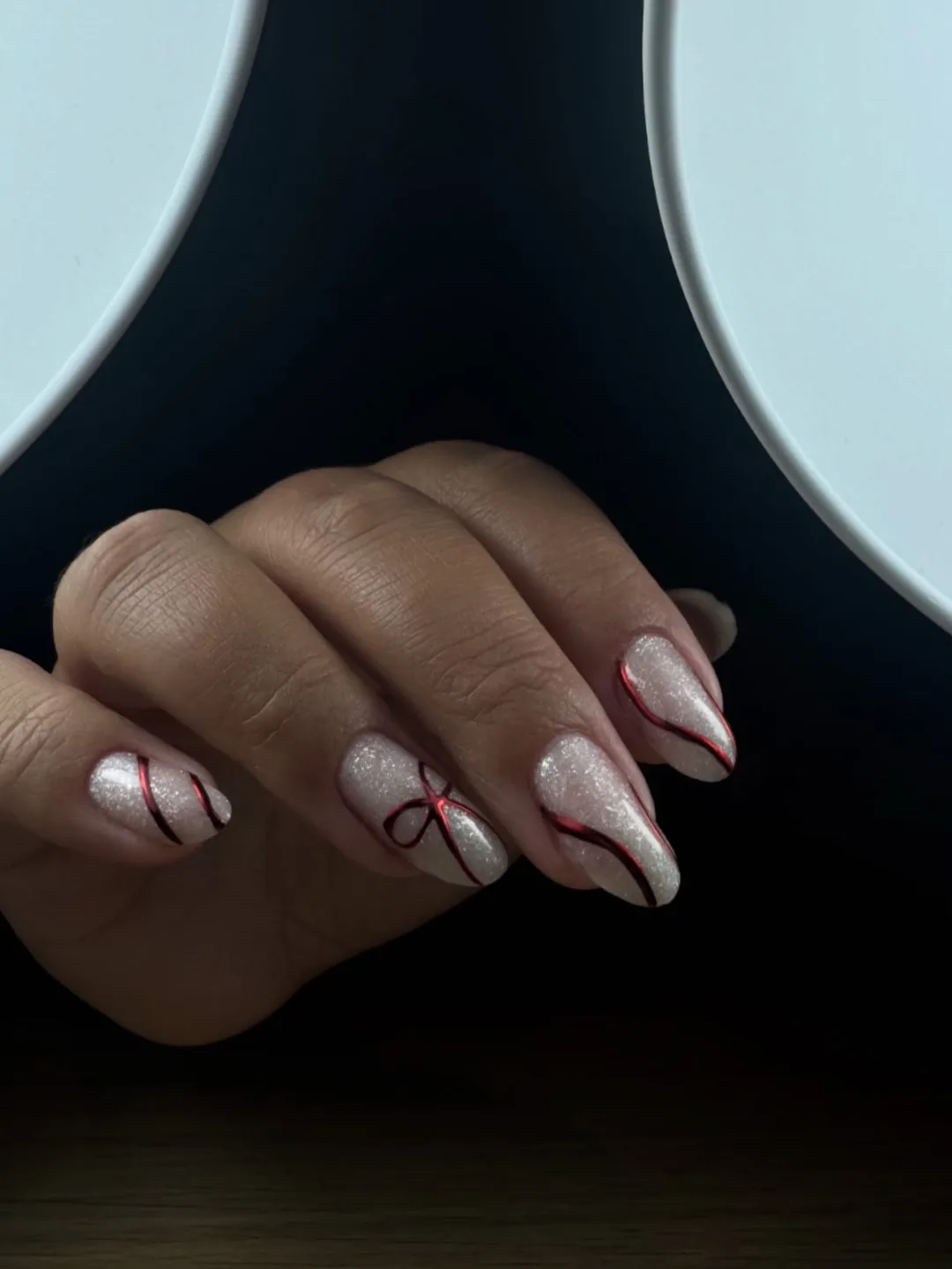 Nail art de Noël : ruban rouge sur base pailletée