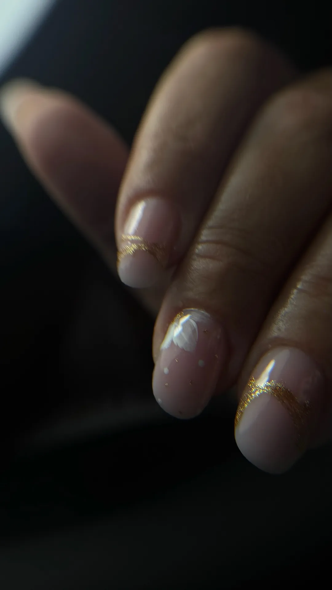 Manucure dorée avec détails floraux délicats