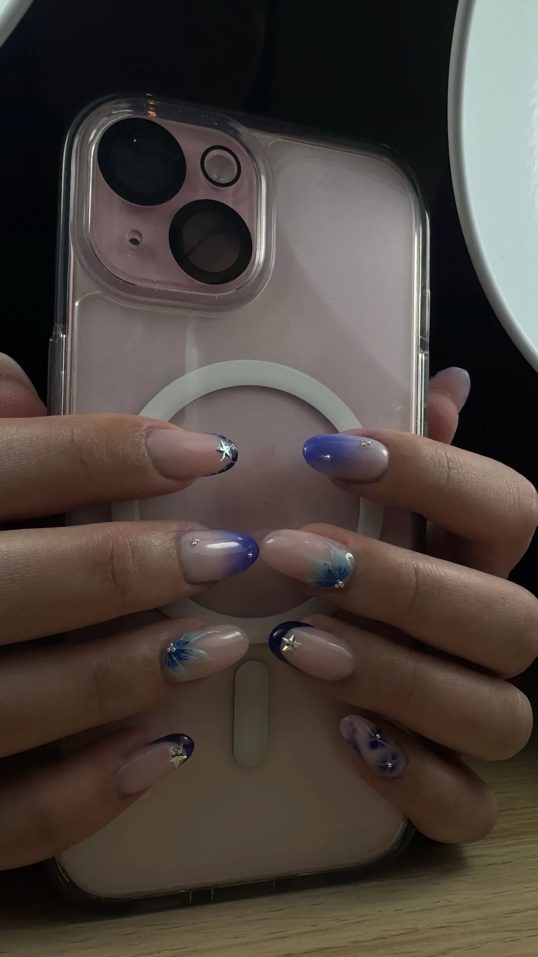 Pose d'ongles bleu dégradé avec étoiles et fleurs — les deux mains