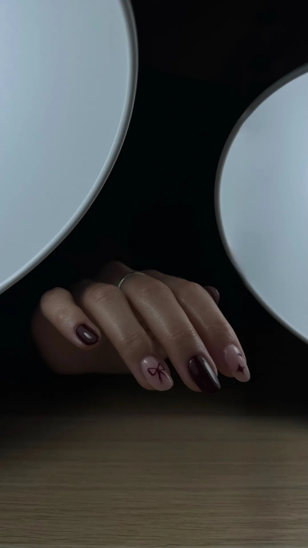 Nail art bordeaux avec nœud dessiné