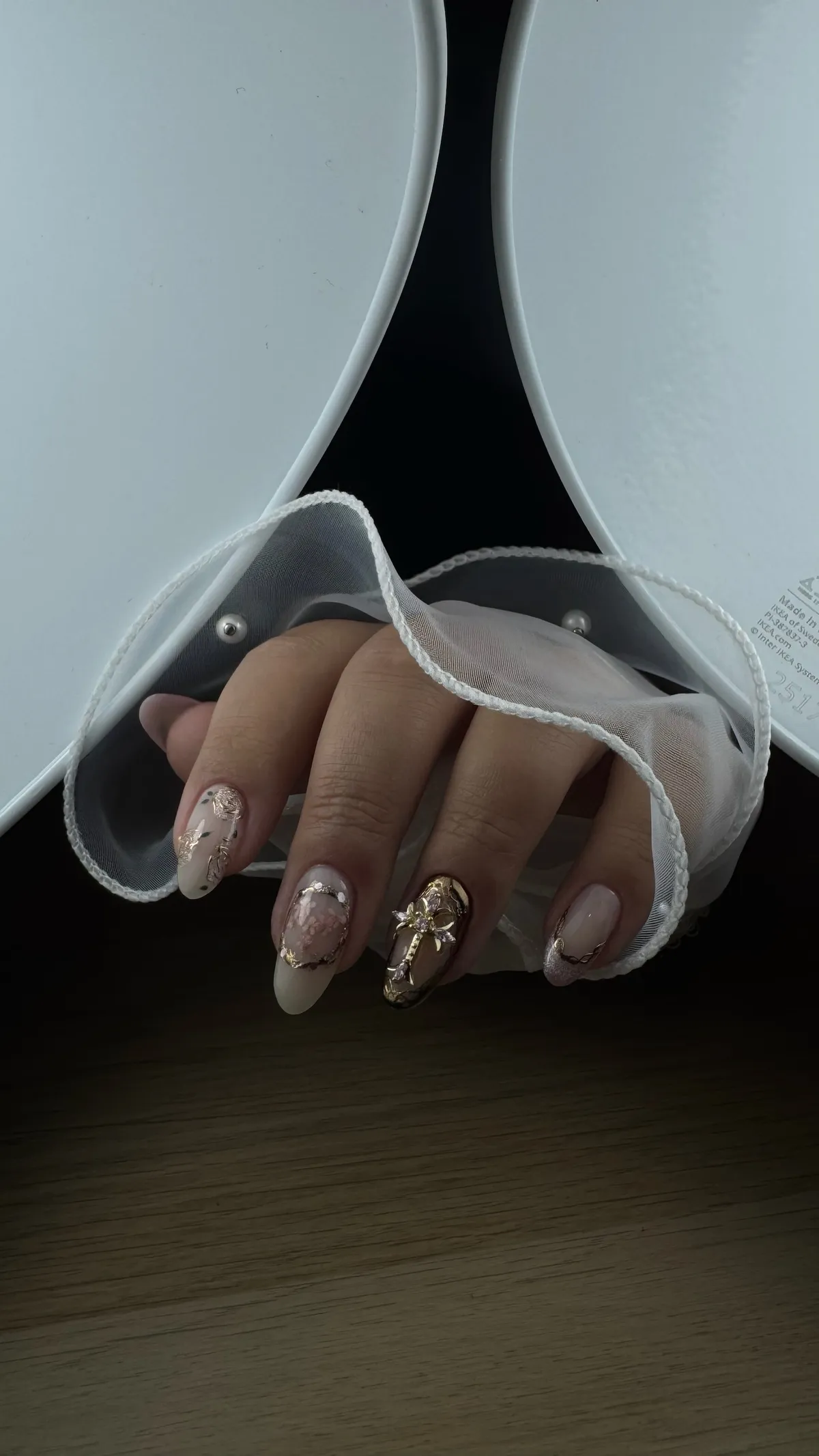 Nail art nude avec nœud doré en relief et feuilles d'or